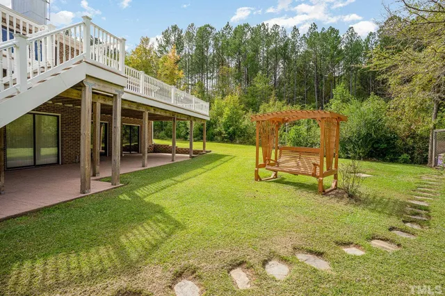 a view of an house with backyard and a tree