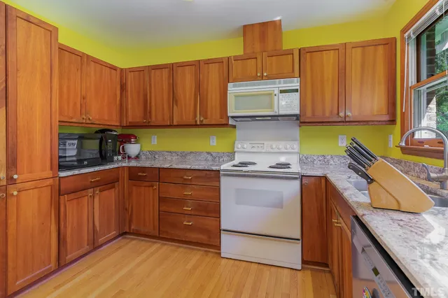 a kitchen with kitchen island granite countertop wooden cabinets a sink and dishwasher