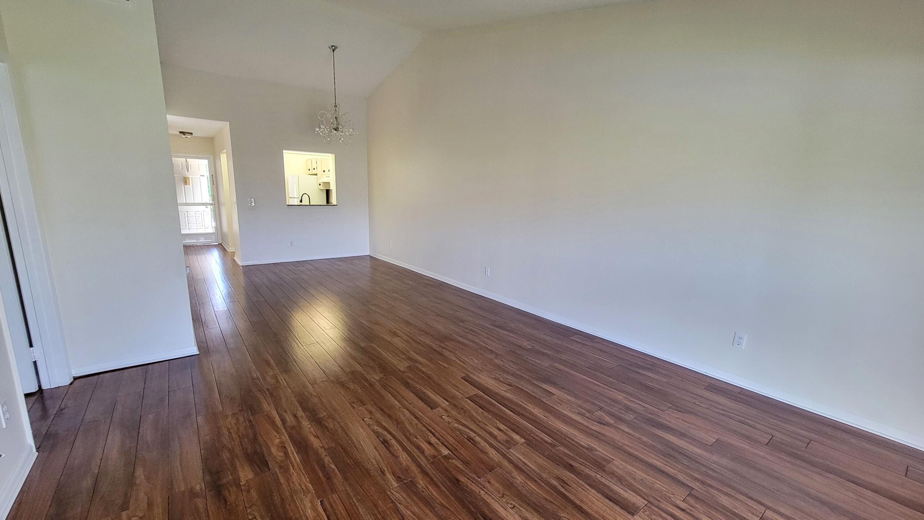 3105 Southeast Aster Lane, Unit 1806 Stuart, FL 34994 - Photo 14 of 45 an empty room with wooden floor and windows
