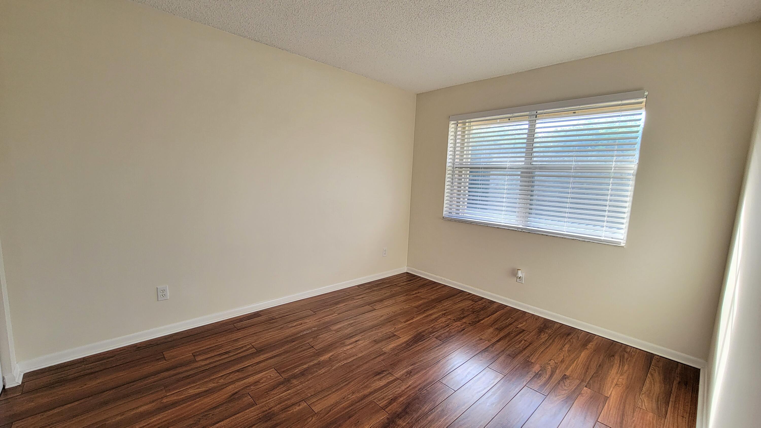 3105 Southeast Aster Lane, Unit 1806 Stuart, FL 34994 - Photo 23 of 45 a view of an empty room with wooden floor and a window