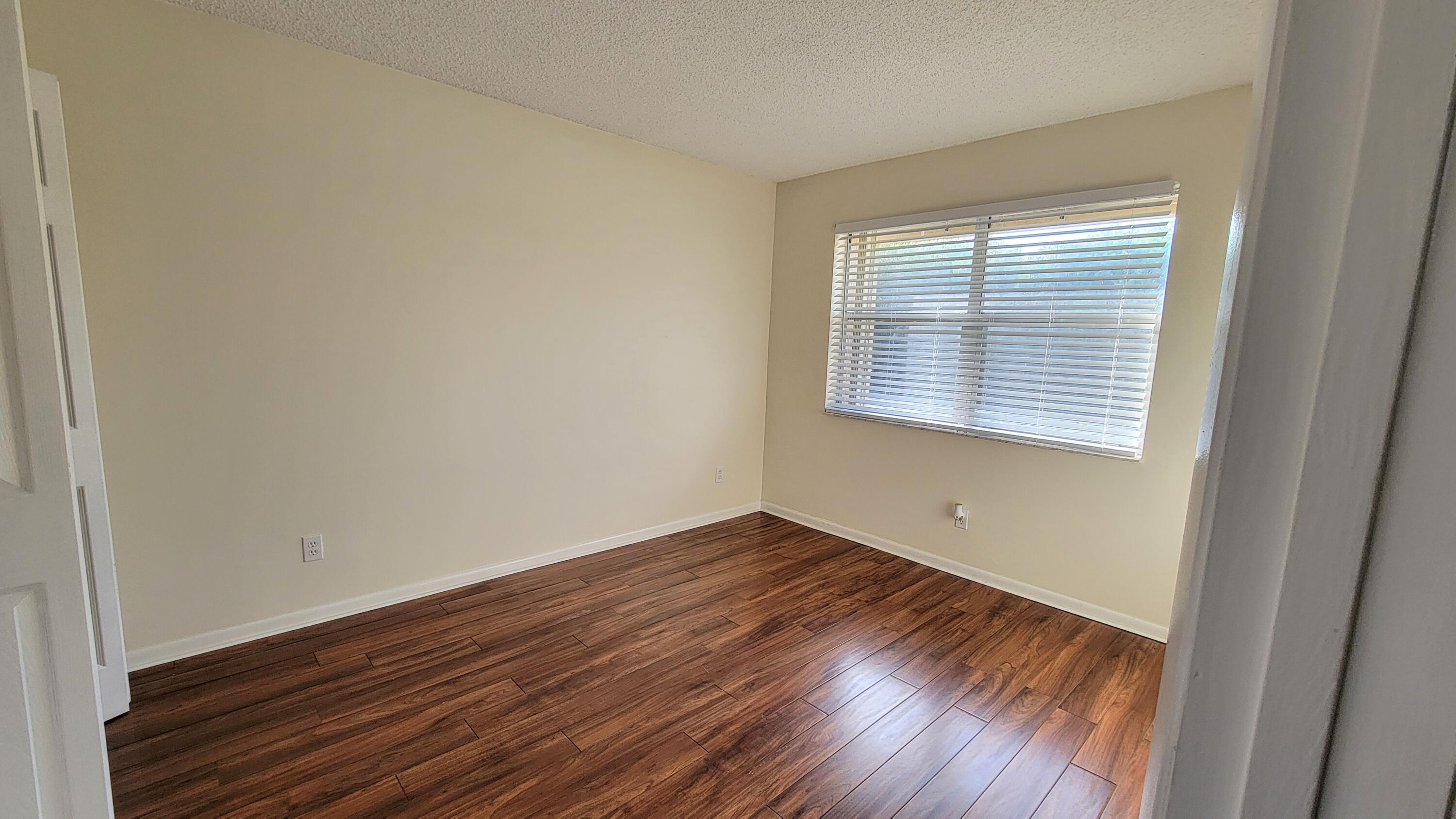 3105 Southeast Aster Lane, Unit 1806 Stuart, FL 34994 - Photo 24 of 45 a view of an empty room with wooden floor and a window