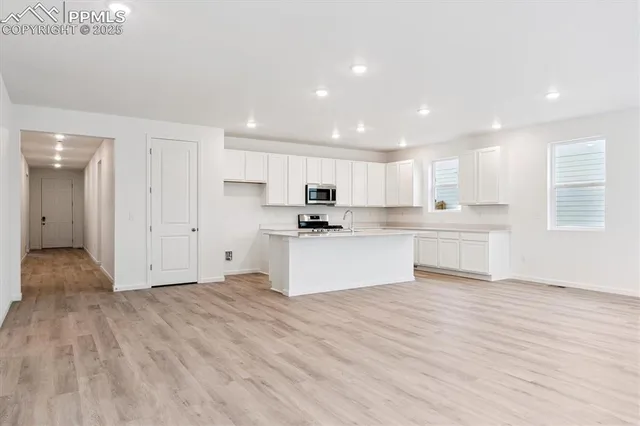 a view of kitchen with granite countertop cabinets and refrigerator