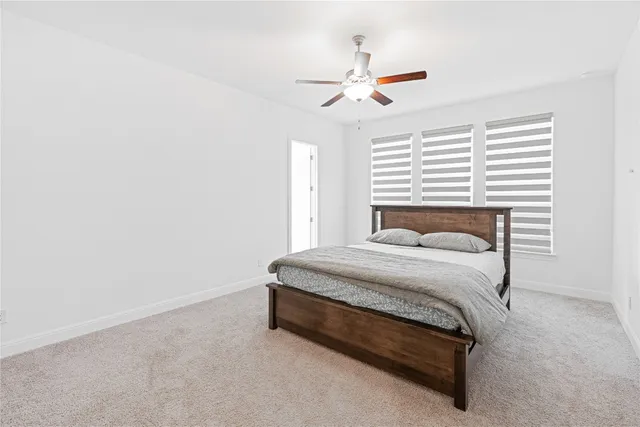 a bed sitting in a bedroom next to a window and a chandelier