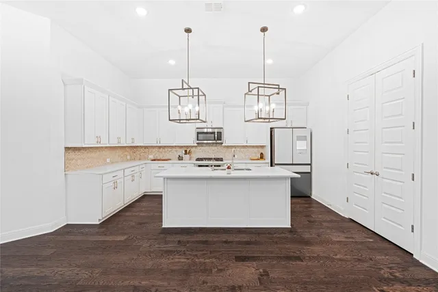 a kitchen with granite countertop white cabinets and white appliances