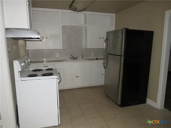 a kitchen with a refrigerator and a stove