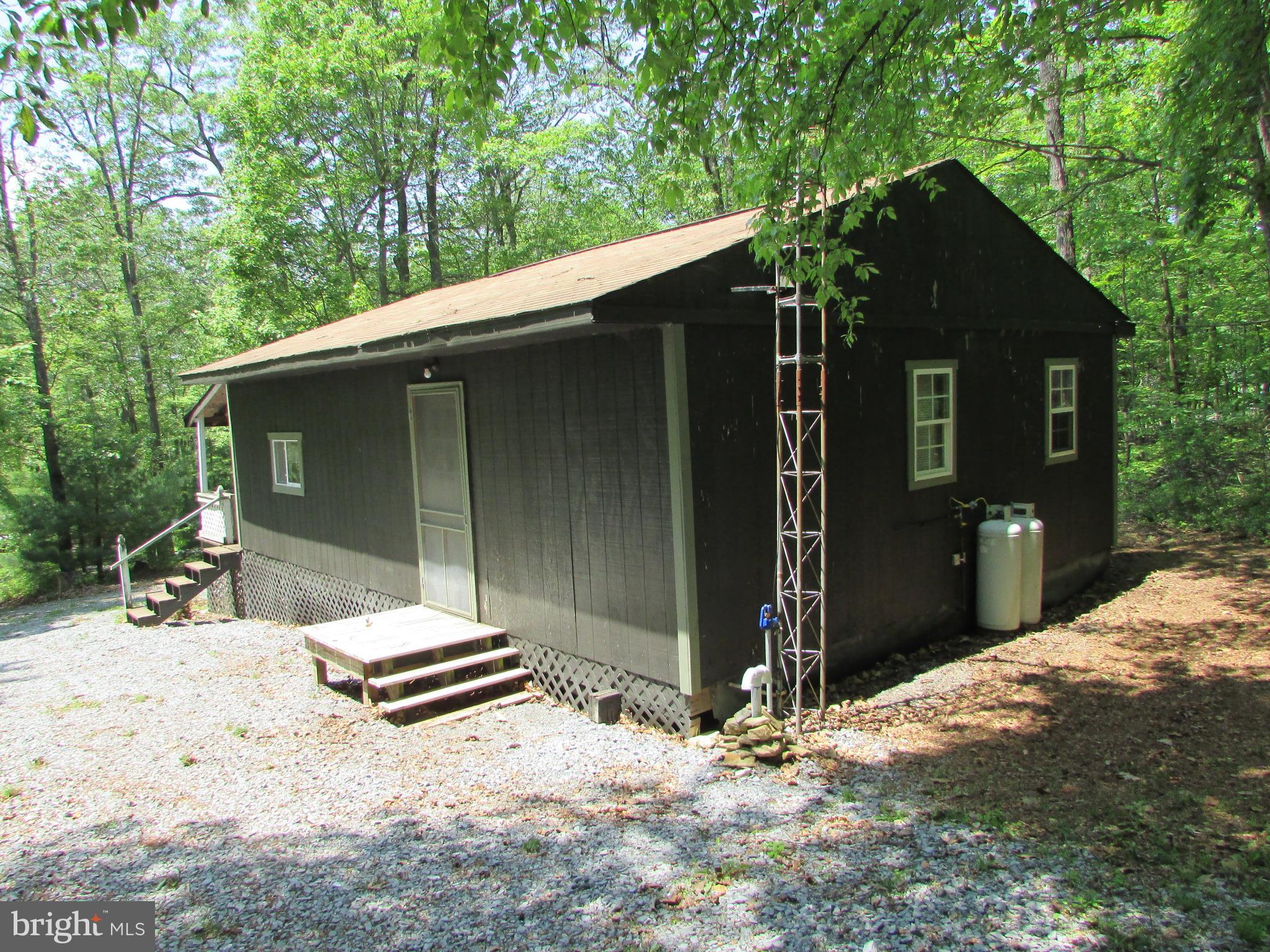 293 Snow Shoe Mountain Forest Road Snow Shoe, PA 16874 - Photo 26 of 38 a backyard of a house with table and chairs under an umbrella