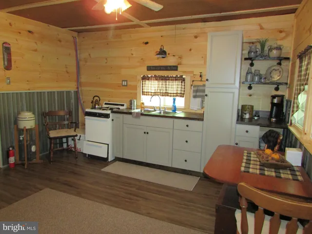 a kitchen with stainless steel appliances wooden floor and a refrigerator