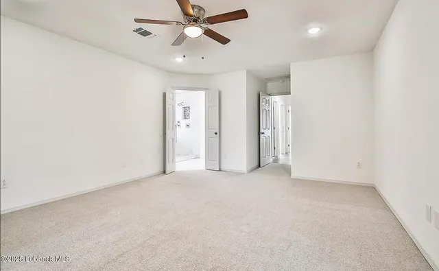 an empty room with chandelier fan