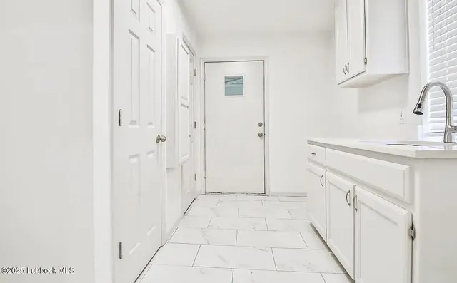 a view of a kitchen with white cabinets