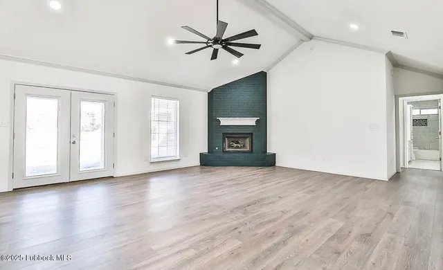 a view of an empty room with a window and a kitchen