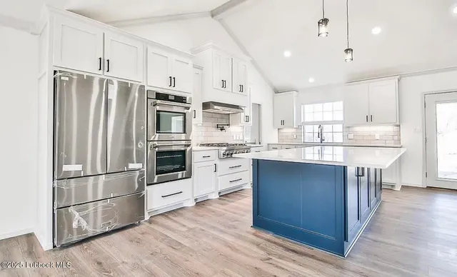 a kitchen with stainless steel appliances a refrigerator sink and cabinets