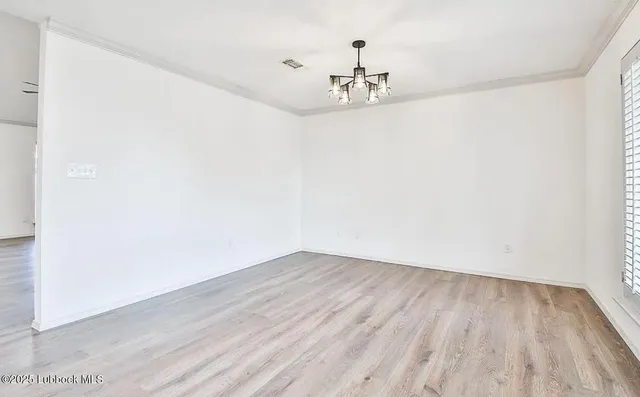 a view of a room with wooden floor and chandelier