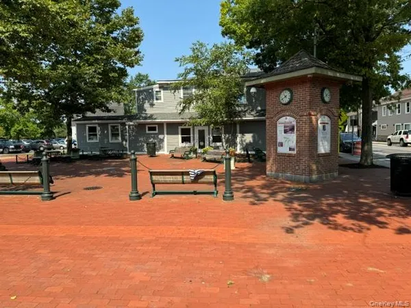 a front view of house with yard and trees in the background