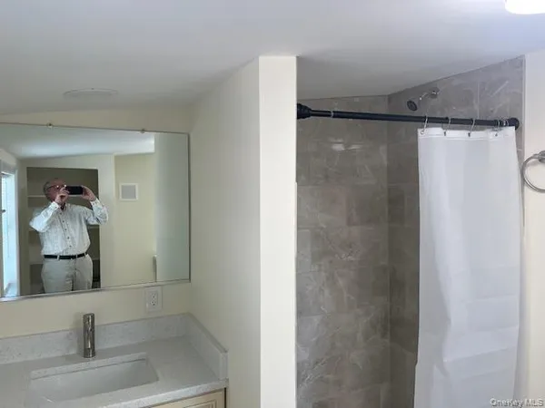a bathroom with a glass shower door and a sink