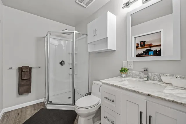 a bathroom with a granite countertop toilet sink and mirror
