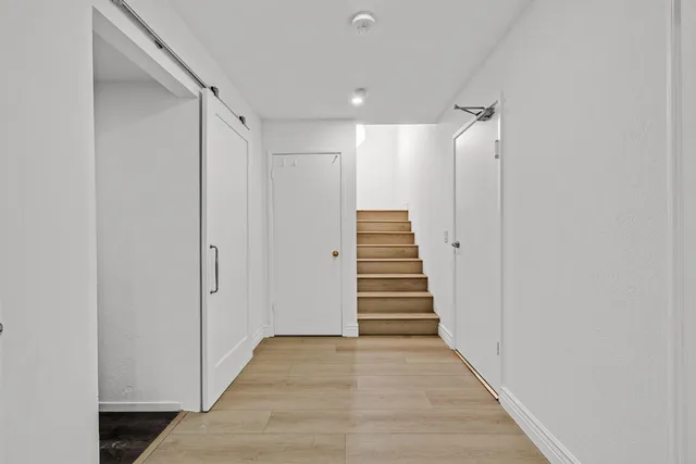 a view of a hallway with wooden floor and staircase