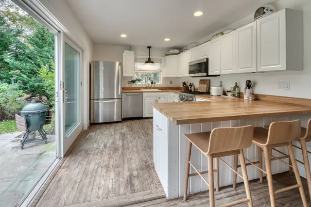 a kitchen with a table chairs refrigerator and cabinets