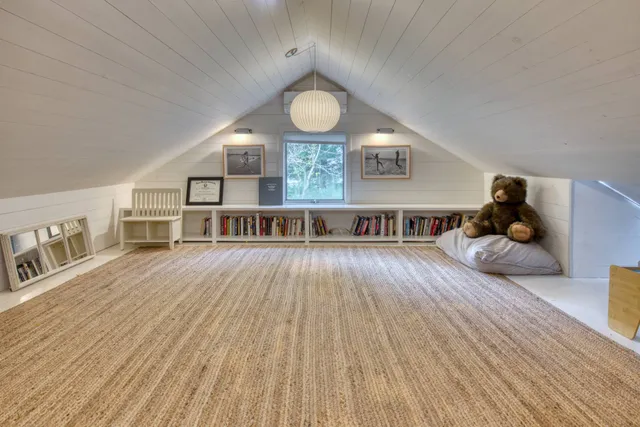 a living room with a bed and a book shelf
