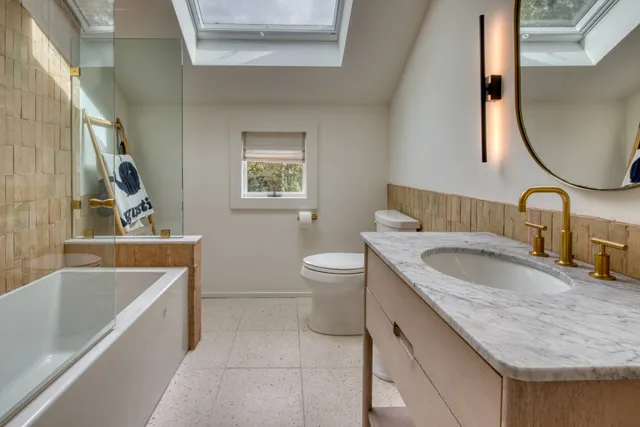 a bathroom with a granite countertop sink a toilet and bathtub