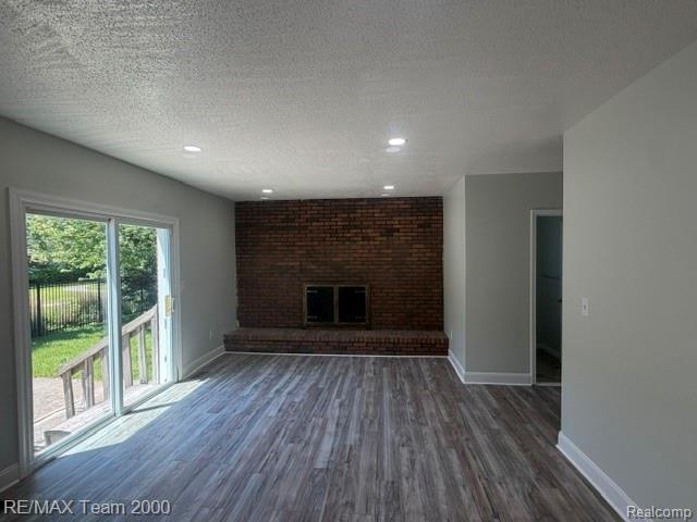 580 Palmerston Street River Rouge, MI 48218 - Photo 14 of 19 Open concept living area featuring a brick fireplace, wood-finish flooring, recessed lighting, and a sliding glass door leading to an outdoor deck