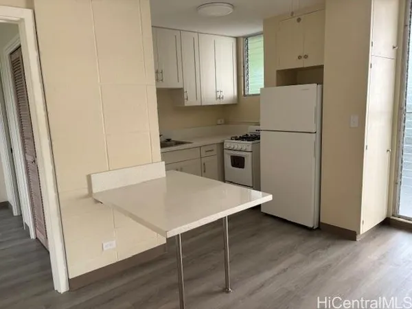 a kitchen with appliances a refrigerator and wooden floor