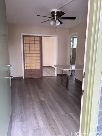 a view of a livingroom with wooden floor and a ceiling fan
