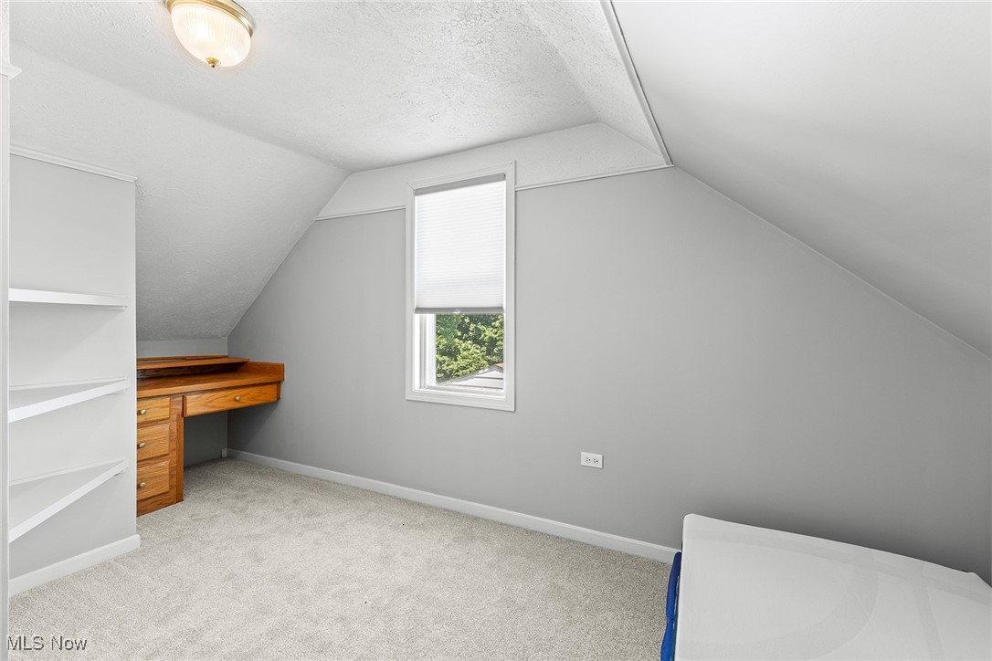430 Stanley Road Akron, OH 44312 - Photo 18 of 36 Bonus room featuring carpet flooring, a textured ceiling, vaulted ceiling, and a desk