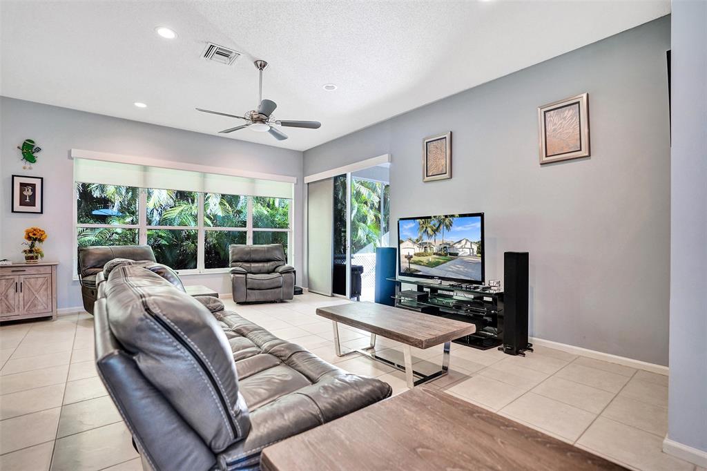 7992 Rockford Road Boynton Beach, FL 33472 - Photo 17 of 48 a living room with furniture a large window and a flat screen tv