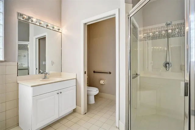 a bathroom with a double vanity sink toilet and shower