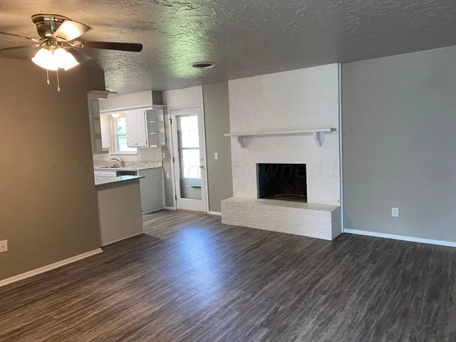 wooden floor fireplace and windows in an empty room