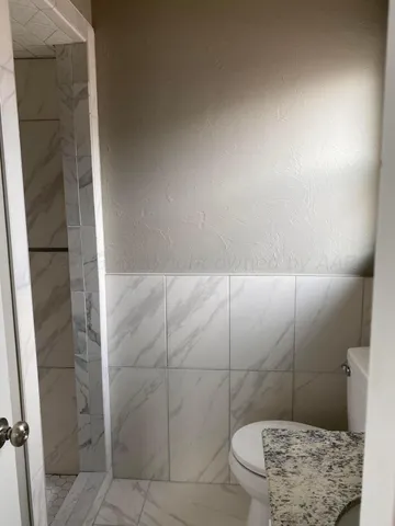 a bathroom with a toilet and a shower