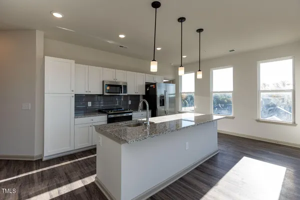 a kitchen with stainless steel appliances granite countertop a sink a stove and a refrigerator