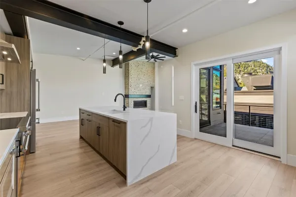 a large white kitchen with a large window a sink and stainless steel appliances