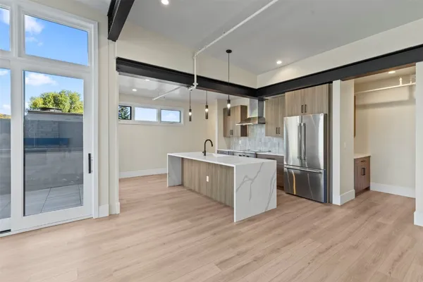 a kitchen with stainless steel appliances granite countertop a refrigerator a sink and a stove