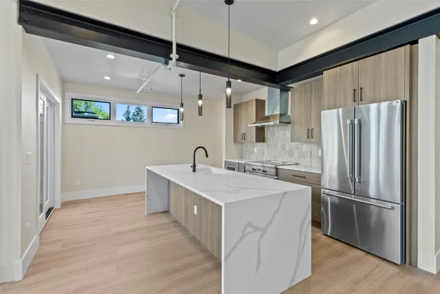 a kitchen with stainless steel appliances granite countertop a refrigerator a sink and a stove