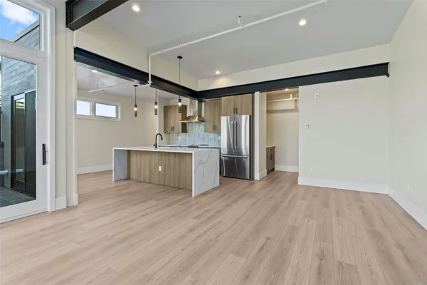 a view of a kitchen with a fridge and wooden floor