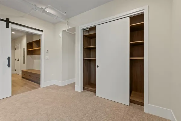 a view of an empty room with cabinet and a bathroom
