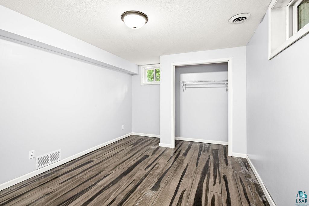 4002 Old Midway Road Hermantown, MN 55810 - Photo 11 of 19 Unfurnished bedroom with a textured ceiling, a closet, and epoxy flooring