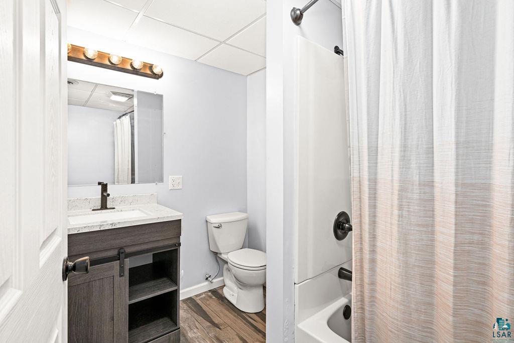 4002 Old Midway Road Hermantown, MN 55810 - Photo 13 of 19 Full bathroom with shower / tub combo, epoxy floors, a drop ceiling, toilet, and vanity