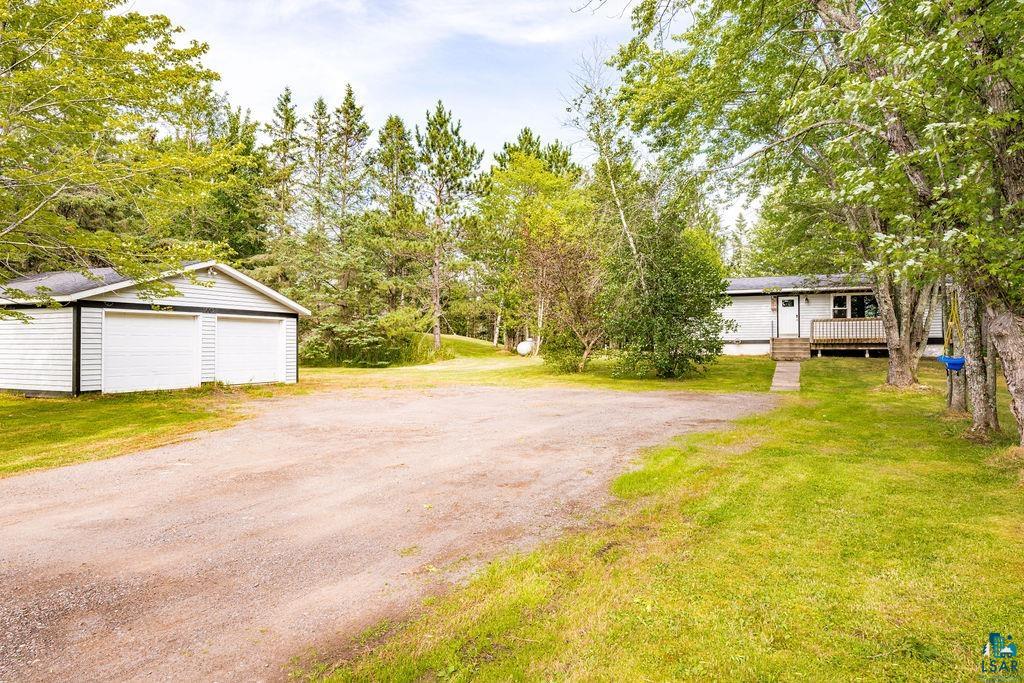4002 Old Midway Road Hermantown, MN 55810 - Photo 17 of 19 View of yard with a garage, an outbuilding, and a deck