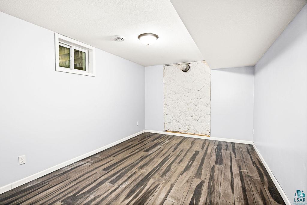 4002 Old Midway Road Hermantown, MN 55810 - Photo 10 of 19 Spare room featuring epoxy flooring and a textured ceiling