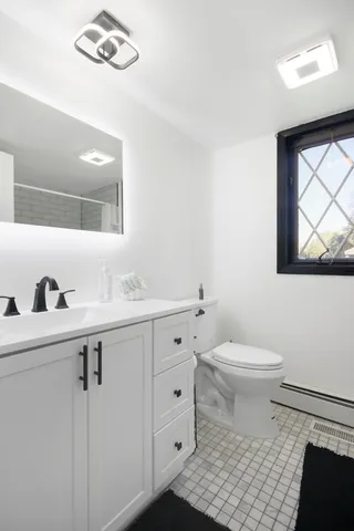 a bathroom with a sink a toilet and a mirror