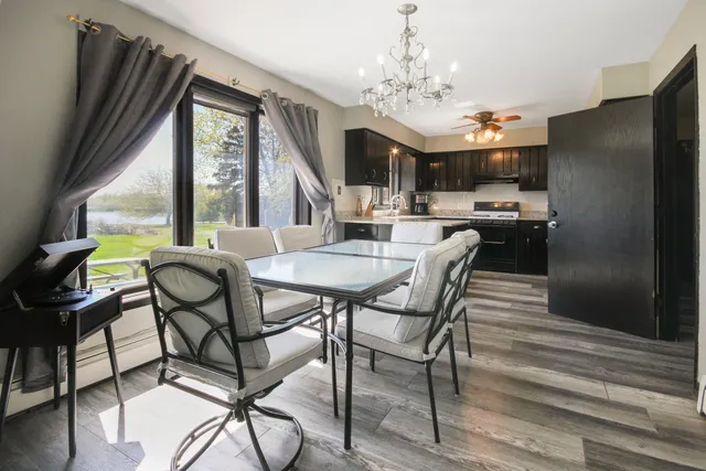 a view of a dining room with furniture a chandelier and wooden floor