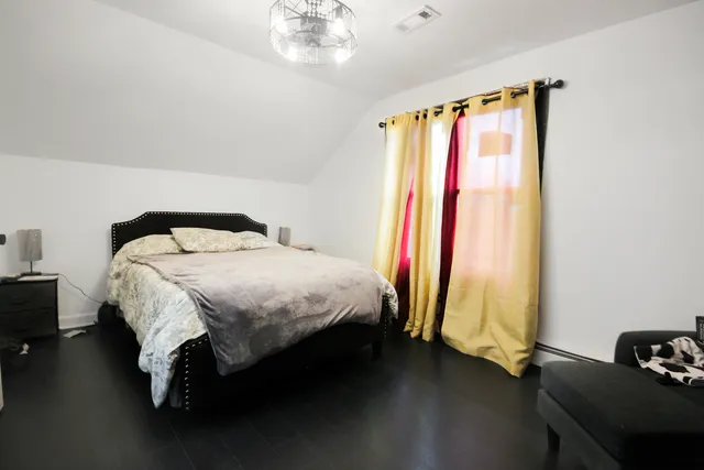 a bed sitting in a bedroom next to a window