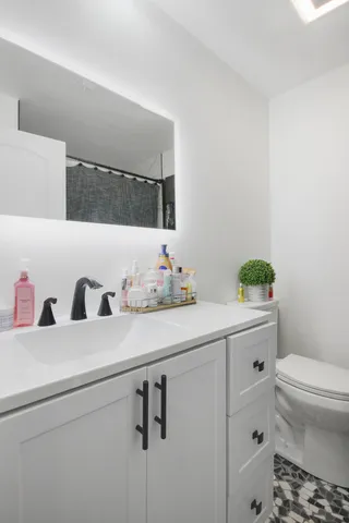 a bathroom with a granite countertop sink a toilet and a mirror