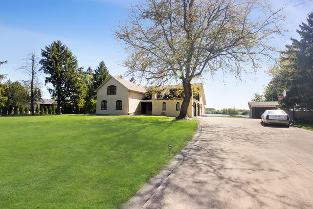 a front view of a house with a yard and trees