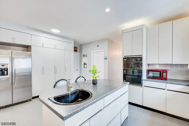 a kitchen with white cabinets and appliances
