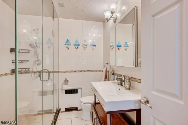 a bathroom with a shower sink vanity and mirror