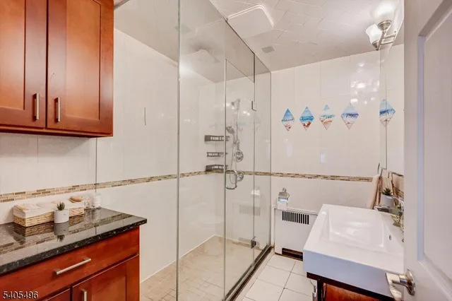 a bathroom with a granite countertop sink a toilet and shower