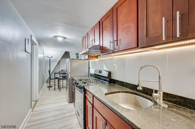 a kitchen with stainless steel appliances granite countertop a sink stove and cabinets